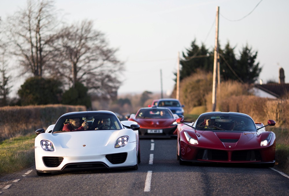 Paul Bailey dirige seu Porsche branco e a esposa, Selena, a Ferrari vermelha (Foto: Grosby Group)