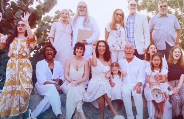 Demi Moore, de vestido estampado, posa junto de amigos e familiares e com o x Bruce Willis, sentado, de branco (Foto: Reprodução)