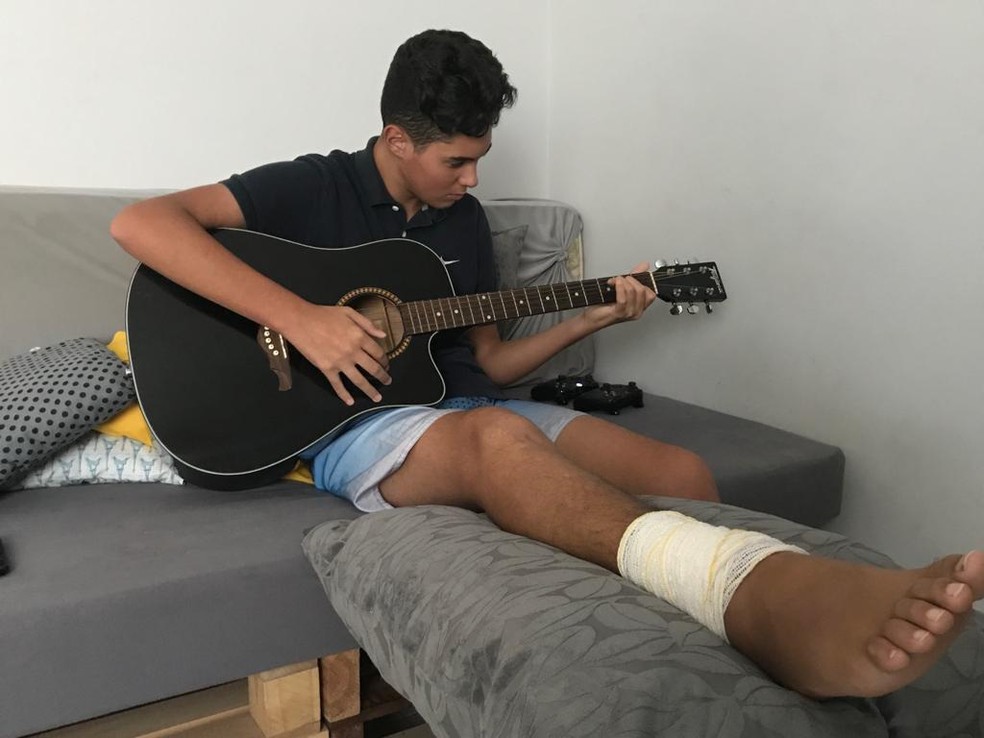 Leonardo Martinez Santos está aprendendo a tocar violão enquanto se recupera de lesão no pé direito.  — Foto: Natan Lira/G1