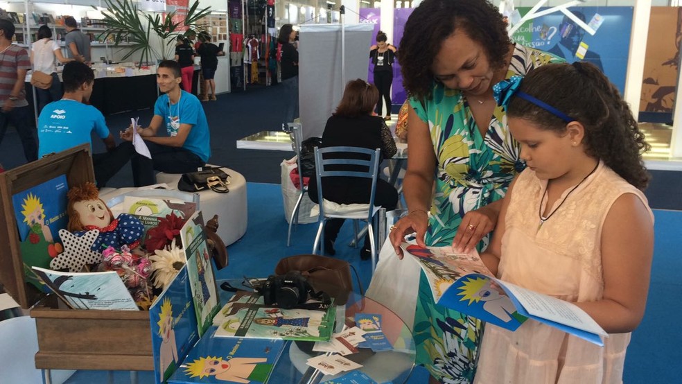 Escritora Márcia Baldine mostra livros para crianças na Bienal (Foto: Carolina Sanches/G1)