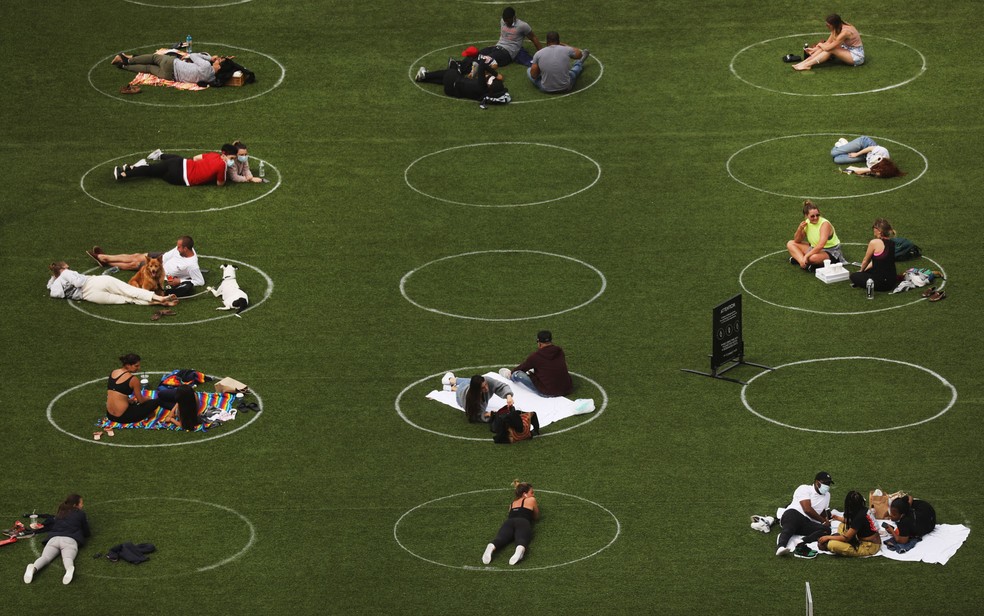 Pessoas ocupam círculos desenhados para encorajar o distanciamento social no Domino Park, em Nova York, nos EUA, na segunda-feira (18) — Foto: Spencer Platt/Getty Images/AFP