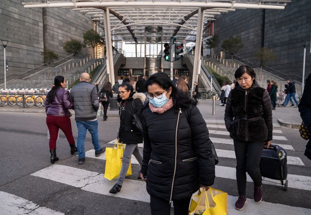 MILAN, ITALY - 2020/02/24: A woman wearing a face mask crossest the street at Porta Garibaldi Station. Precautionary measures, such as wearing face masks have been taken by citizens and tourists in Milan, for dealing with the fear of being infected by Cor (Foto: Valeria Ferraro/SOPA Images/LightRocket via Getty Images)