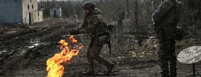 Militares ucranianos acendem fogueira com pólvora para se aquecer perto da cidade de Bakhmut — Foto: ARIS MESSINIS/AFP