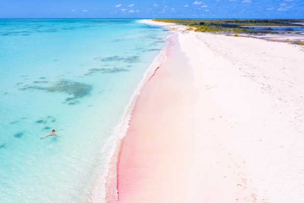 Aerial view of woman floating in turquoise sea, Pink Sand Beach, Barbuda, Antigua and Barbuda, Caribbean, Leeward Islands, West Indies (Foto: Getty Images)