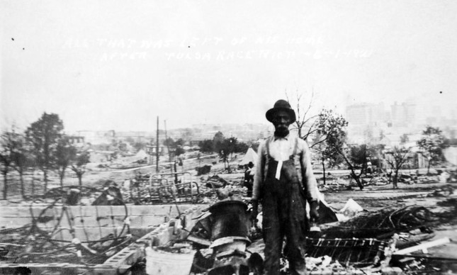 Homem em meio a ruínas de Greenwood após Massacre de Tulsa, em 1921