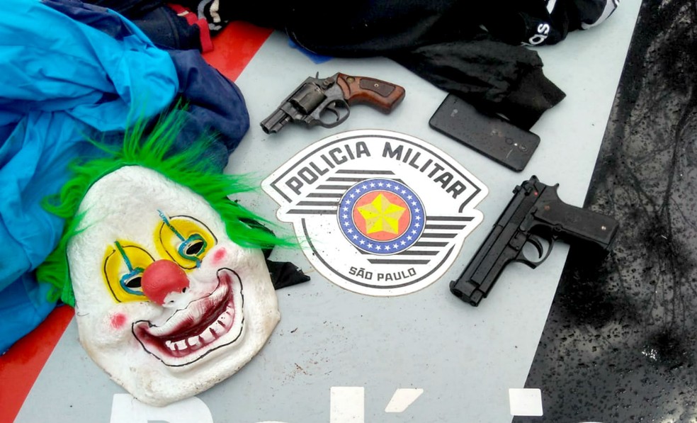 Com suspeitos, PM apreendeu um revólver, uma pistola falsa e máscara  — Foto: Polícia Militar/Divulgação