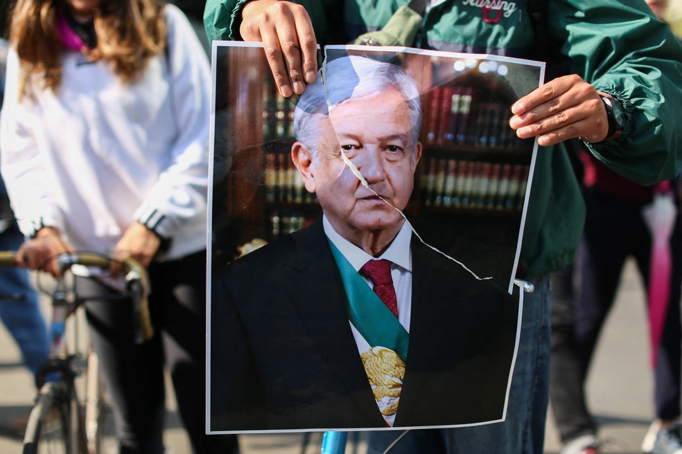 Manifestante rasga cartaz com foto do presidente mexicano Andres Manuel Lopez Obrador durante marcha na Cidade do México — Foto: ODRIGO OROPEZA / AFP