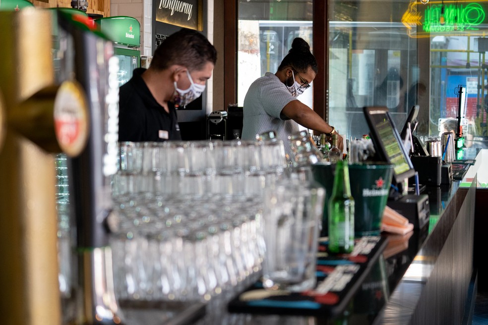 Funcionários de bar na Vila Madalena, em São Paulo, utilizam máscara durante a reabertura — Foto: Marcelo Brandt/G1