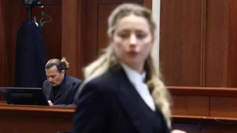 Johnny Depp testemunhou no processo; Amber Heard (fora de foco) estava presente (Foto: Getty Images via BBC News)