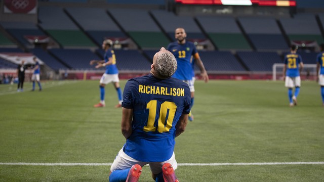 Richarlison comemora o gol pela seleção brasileira. Daniel Alves observa. 