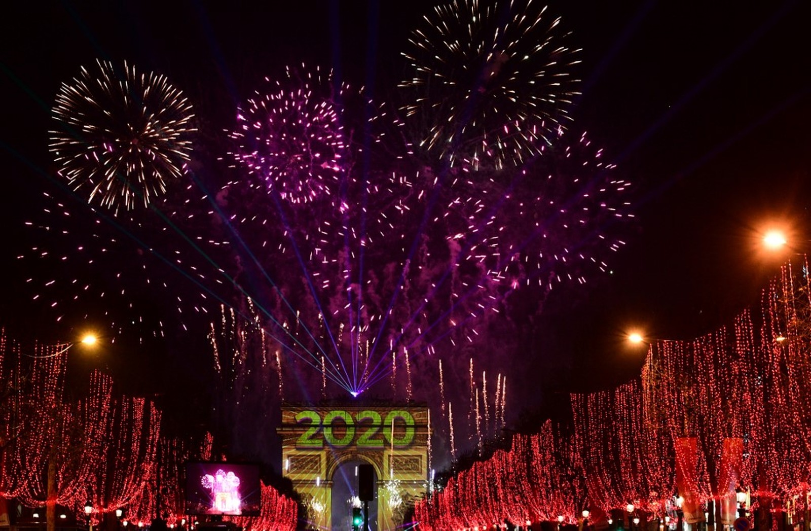  Fogos de artifício iluminam o céu sobre o Arco do Triunfo durante as comemorações do Ano Novo na avenida Champs Elysees, em Paris — Foto: Martin Bureau/AFP