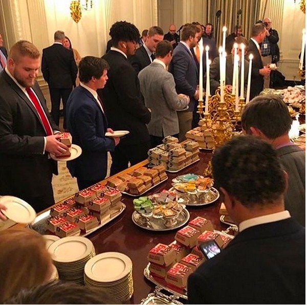 A mesa com habúrgueres, pizzas e nuggets oferecida por Donald Trump aos atletas campeões univesitários em visita à Casa Branca (Foto: Instagram)