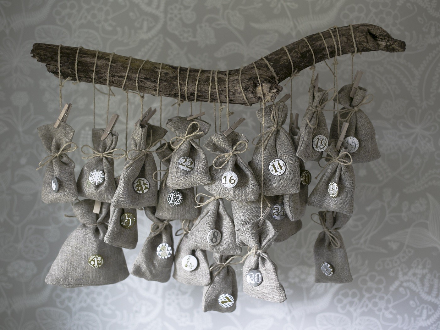 Homemade Christmas calendar Scandinavian style. Small linen bags hanging on a branch. (Foto: Getty Images)
