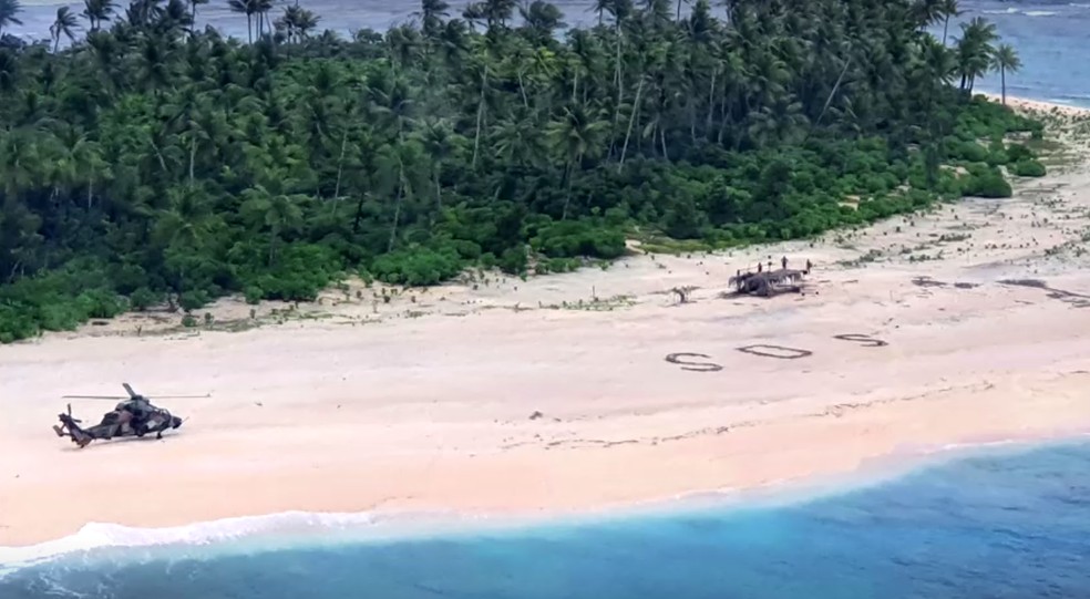 Homens foram resgatados após escreverem SOS na areia — Foto: Reuters