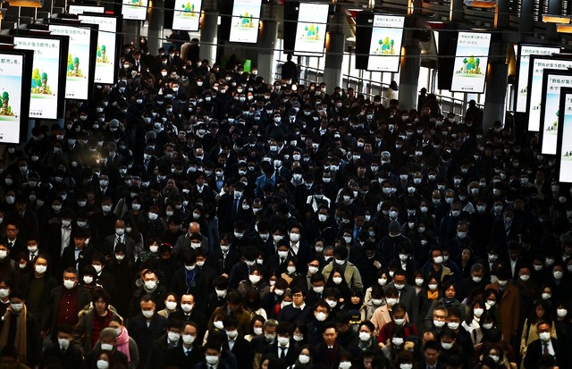 Mask-clad commuters make their way to work during morning rush hour at the Shinagawa train station in Tokyo on February 28, 2020. - Tokyo's key Nikkei index plunged nearly three percent at the open on February 28 after US and European sell-offs with inves (Foto: AFP via Getty Images)
