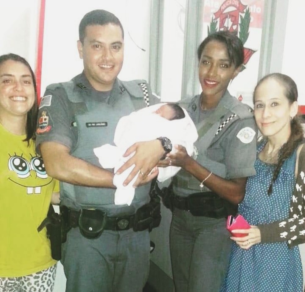 Policiais militares ao lado das mulheres que socorreram o bebê, em Guarujá, SP — Foto: G1 Santos
