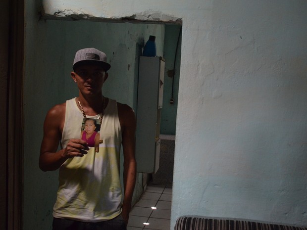 Marcos Freire, do local onde a mãe foi baleada, recorda como a bala entrou pelo portão da casa (Foto: André Resende/G1)