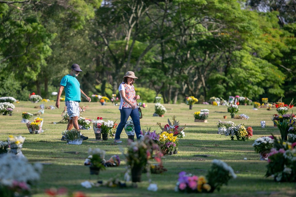 Pessoas levam flores para o túmulo de entes queridos no cemitério de Congonhas, em São Paulo — Foto: Marivaldo Oliveira/Código19 via Estadão Conteúdo