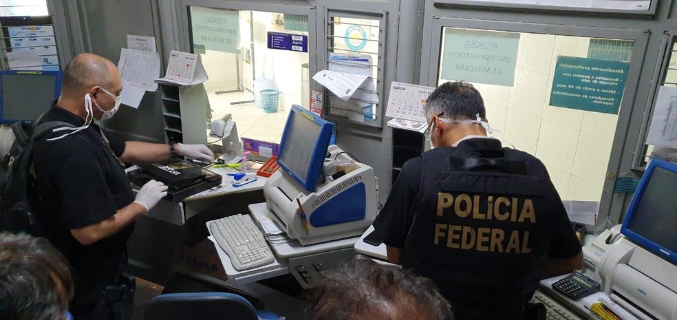 Agentes da Polícia Federal cumprem mandado de busca e apreensão dentro de lotérica investigada em esquema no pagamento do auxílio emergencial em Aurora, no Ceará. — Foto: Divulgação