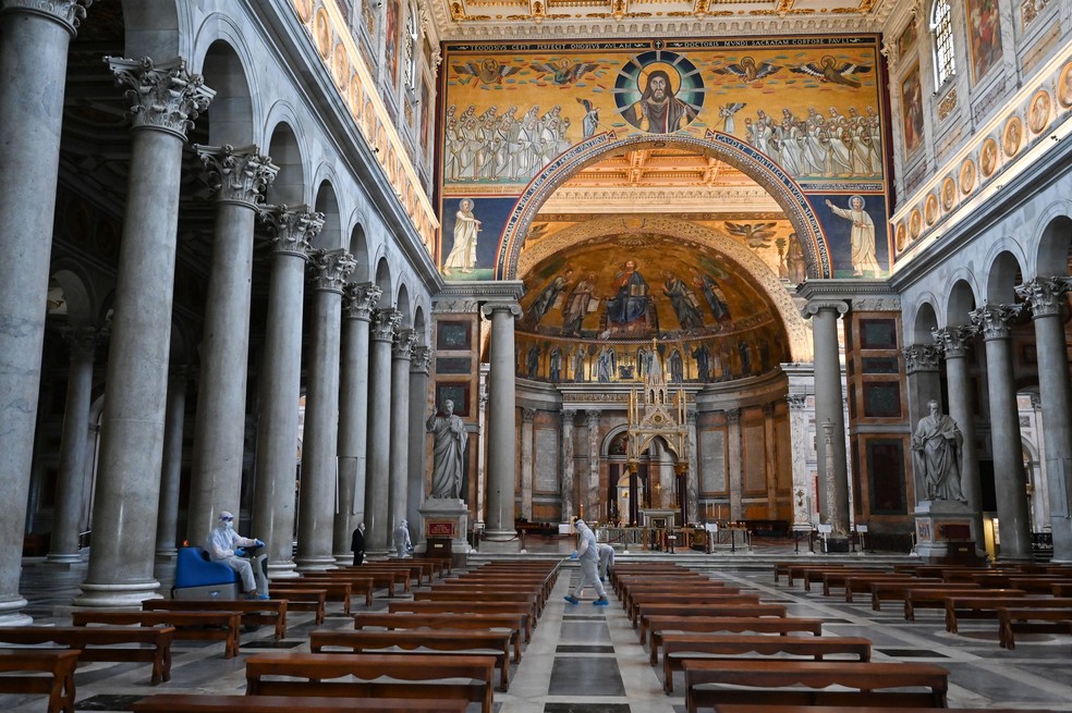 Homens desinfetam o ch&atilde;o do cemit&eacute;rio da Bas&iacute;lica de S&atilde;o Paulo Fora dos Muros, em Roma, na It&aacute;lia, neste s&aacute;bado (16)  &mdash; Foto: Andreas Solaro / AFP
