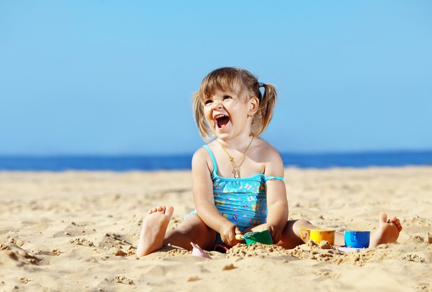 Criança brincando na areia da praia (Foto: Shutterstock)