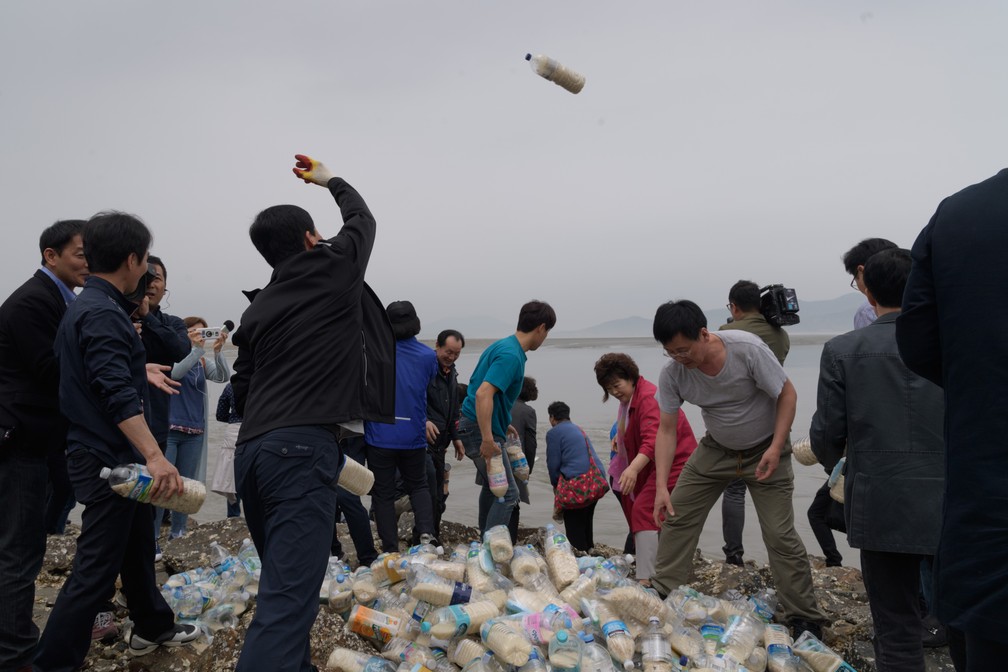 Desertores da Coreia do Norte jogam garrafas ao mar com pen-drives contra o regime (Foto: Ed Jones/AFP )