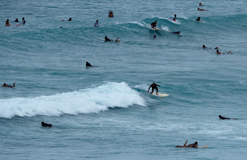 Surfistas aproveitam mar agitado para surfar na praia Waikiki, em Honolulu, no HavaÃ­, na quinta-feira (23)  (Foto: John Locher/AP )