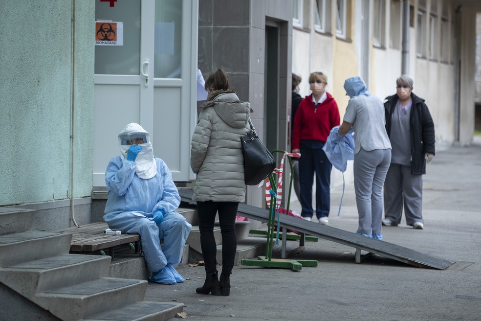 Agente de saúde faz anotações em uma clínica no Zagreb, na Croácia, onde o primeiro caso de coronavírus do país está sendo tratado, nesta terça-feira (25). — Foto: Darko Bandic/AP