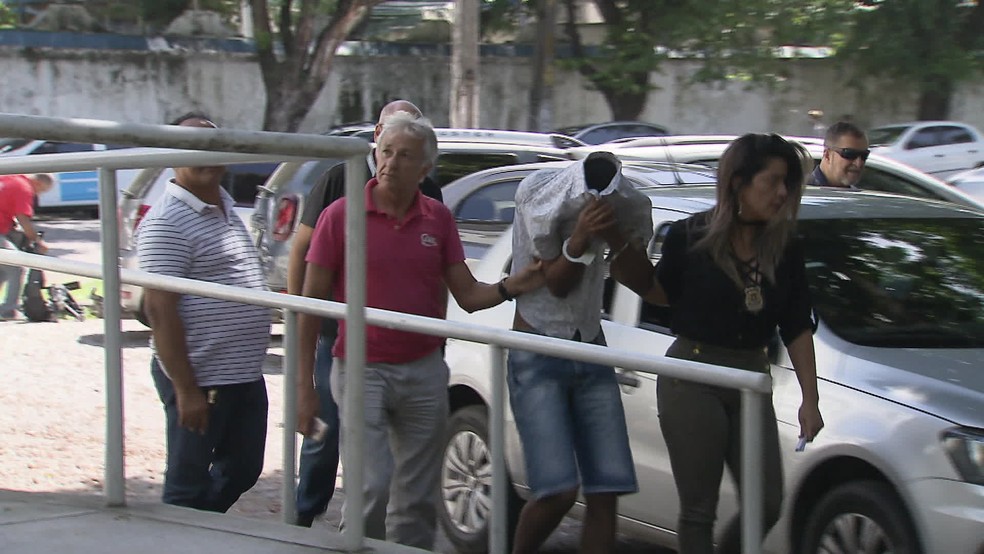 Suspeito de segurar vÃ­tima que teve rosto queimado por soda cÃ¡ustica Ã© levado Ã  Delegacia da Mulher de Santo Amaro, no Centro do Recife â€” Foto: ReproduÃ§Ã£o/TV Globo