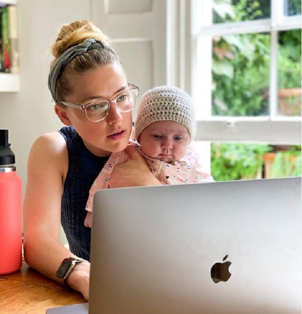 A atriz Amber Heard trabalhando com a filha no colo (Foto: Instagram)