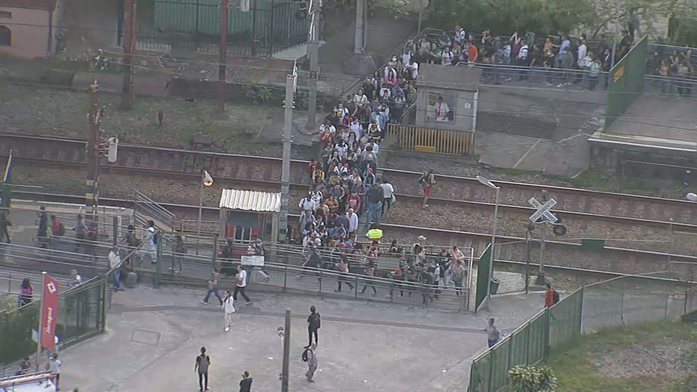 Passageiros nos trilhos, após falhas nas linhas 7-Rubi e 11-Coral na manhã desta sexta (30) — Foto: Reprodução/TV Globo