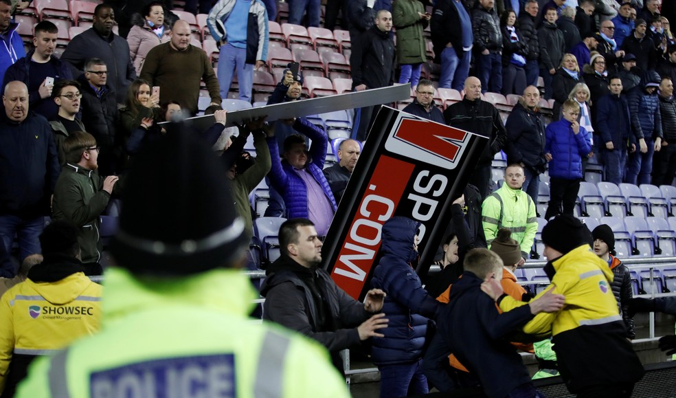 Torcida do Manchester City arremessa placas de publicidade na polícia (Foto: Carl Recine/Reuters)