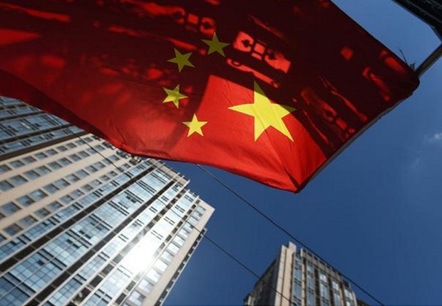 Bandeira chinesa tremula perto de um conjunto de apartamentos em Pequim ; PIB da China ; produção industrial da China ; economia da China ;  (Foto: Greg Baker/AFP/Getty Images)