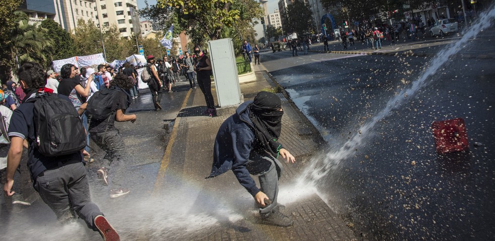 Manifestantes e forças de segurança entram em confronto durante manifestação nesta terça-feira (11) no Chile (Foto: MARTIN BERNETTI / AFP)