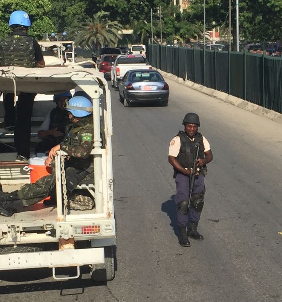 Policial haitiano ao lado de caminhão das forças de paz em seu último dia de patrulha em Porto Príncipe (Foto: Tahiane Stochero/G1)