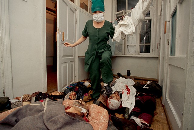 Enfermeira caminha entre cadáveres em um hospital em Grozny, na Primeira Guerra da Chechênia, em 1994 (Foto: Getty Images)