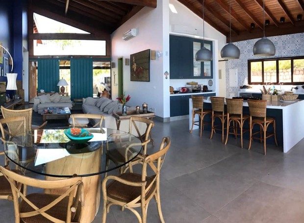 A cozinha se integrada à sala, tornando o ambiente principal da casa funcional e elegante (Foto: AIRBNB / Divulgação)
