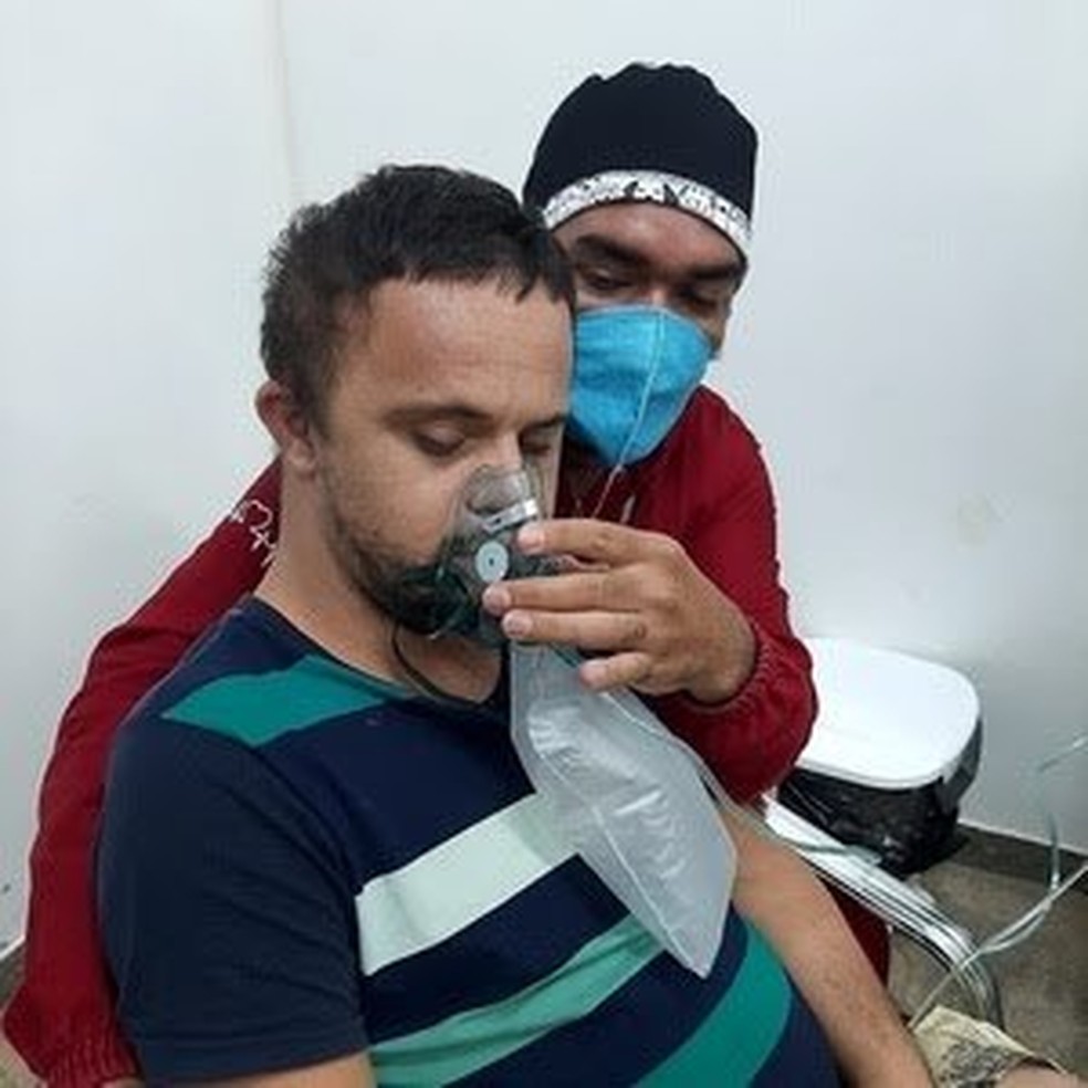 Paciente Emerson Junior Loureiro recebe oxigênio com ajuda de enfermeiro  — Foto: Arquivo pessoal 