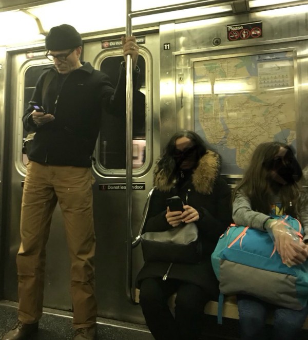 O ator Daniel Day-Lewis flagrado com seu celular antigo dentro do metrô (Foto: Twitter)