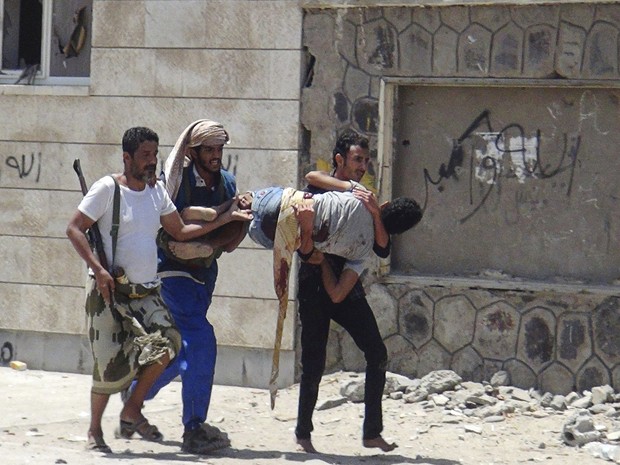 Combatentes leais ao presidente Abd Rabbo Mansour Hadi carregam companheiro ferido em confrontos com os houthis em Áden, no sul do país (Foto: Stringer/Reuters)