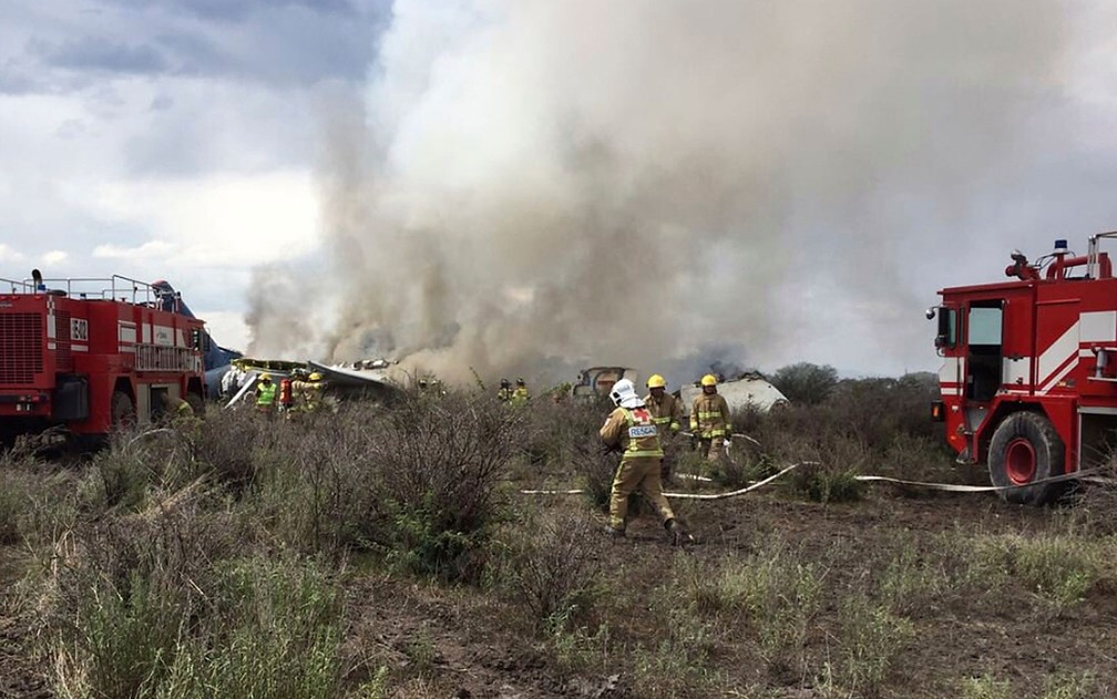 Bombeiros apagam fogo após acidente com avião da Aeroméxico perto do aeroporto de Durango, no México, na terça-feira (31) (Foto: Civil Defense Office of Durango Photo via AP)