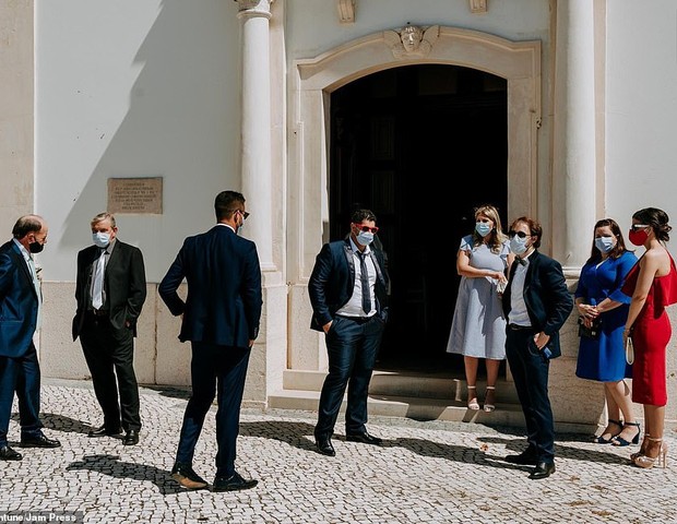 Em Portugal, convidados encontra-se do lado de fora da igreja, vestidos com as suas melhores roupas, mas todos com máscara (Foto: Valtar Antunes)