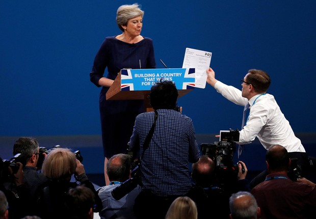 Comediante entrega formulário de demissão à primeira-ministra britânica, Theresa May, durante discurso, em Machester  (Foto: Phil Noble/Reuters)