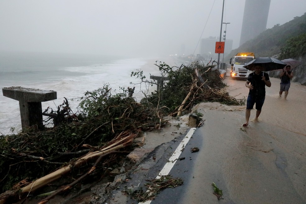 Pessoas passam ao lado de trecho destruÃ­do da ciclovia Tim Maia, no Rio de Janeiro, apÃ³s fortes chuvas  â€” Foto: REUTERS/Sergio Moraes