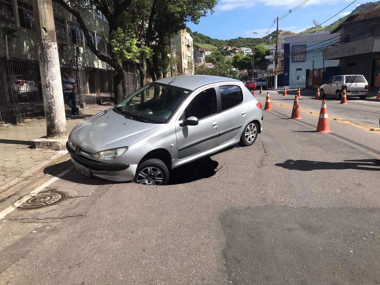 Carro cai em buraco após asfalto ceder em avenida de Vitória