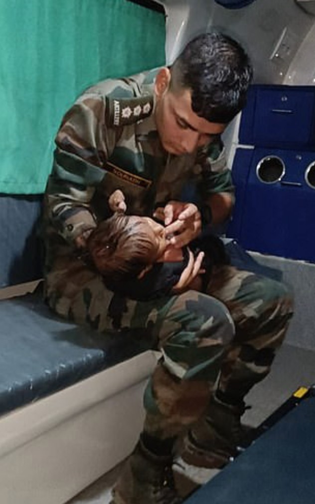Militar prestando atendimento ao menino na ambulância (Foto: Reprodução/The Indian Express)