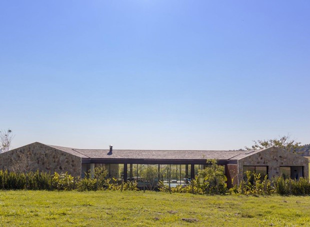 Casa contemporânea combina cimento queimado, pedra, madeira e vidro, e tem telhado aparente (Foto: Adriano Pacelli/Divulgação)
