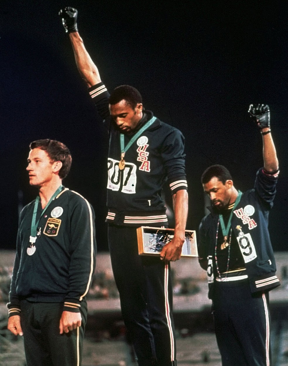 Gestos de protesto durante o hino dos EUA não são limitados ao presente - os atletas Tommie Smith e John Carlos levantaram os punhos cerrados, usando uma luva preta, durante a cerimônia de entrega de medalha dos Jogos Olímpicos do México de 1968 — Foto: AP Photo/File