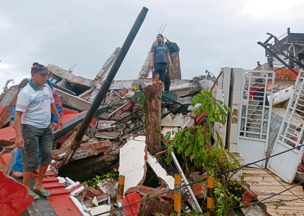 Moradores vasculham destroços em Mamuju, na Indonésia, após terremoto desta sexta-feira (15) — Foto: Rudy Akdyaksyah/AP Photo