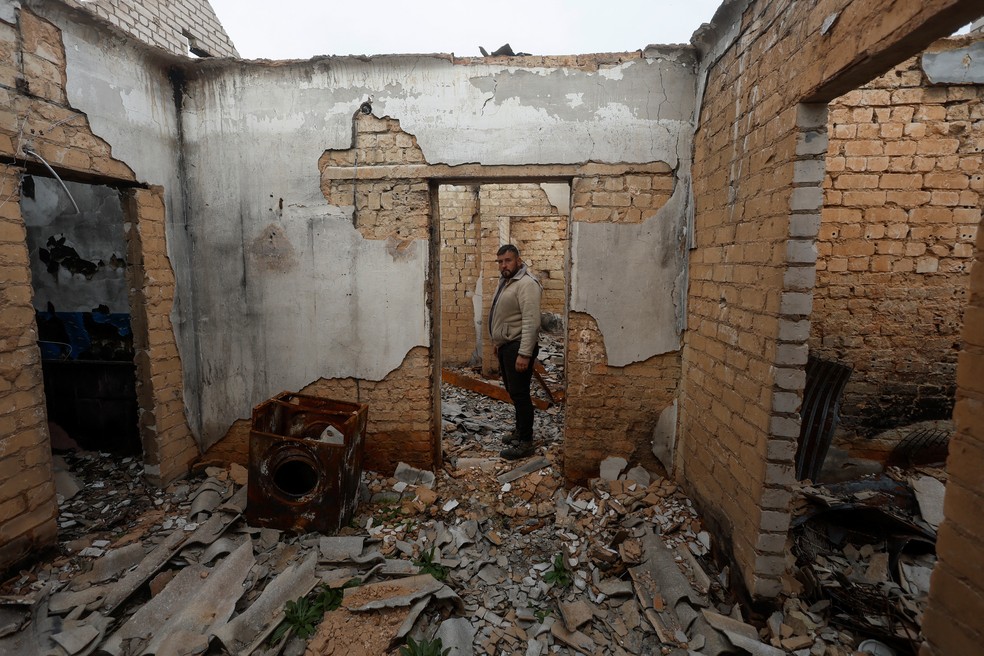 Ucraniano mostra casa destruída por soldados russos na vila de Blahodatne, na região de Kherson, na Ucrânia, em 11 de novembro de 2022 — Foto: REUTERS/Valentyn Ogirenko